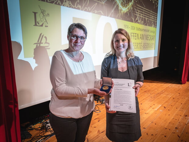 Bärbel Wein (links) erhält von Bürgermeisterin Sarina Pfründer (rechts) die Medaille der Stadt Lauffen a.N. für besondere Leistungen in Gold am 10.5.2024 im Rahmen des Festabends "50 Jahre Städtepartnerschaft Lauffen a.N. - La Ferté-Bernard"