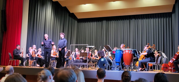 Dirigent des JKO und Musikschulleiter Thomas Conrad mit dem Solisten Kristian Koppányi und dem Orchester