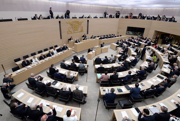 Landtag Baden-W&uuml;rttemberg: Parlamentssaal mit halbkreisf&ouml;rmiger Anordnung von Abgeordneten w&auml;hrend einer Sitzung.
