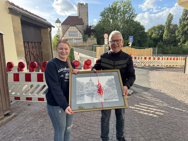Frau Sieber vom SRH Bad Wimpfen überreichte Stadtarchivar Dr. Axel Koster eine limitierte und signierte Bleistiftzeichnung der Regiswindiskirche