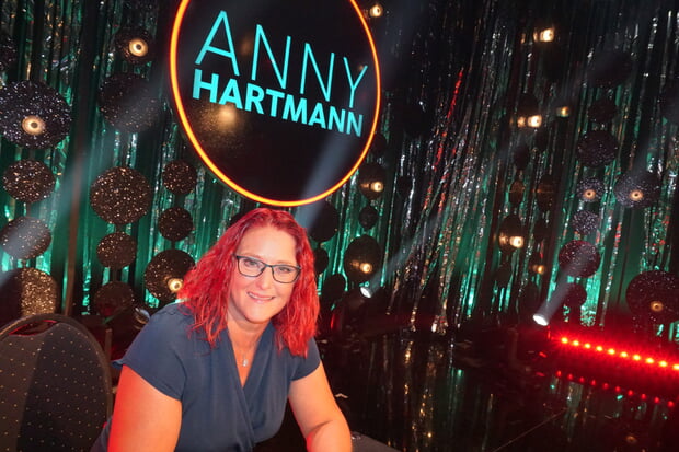 Kabarettistin Anny Hartmann auf der Bühne (Frau mit Brille und roten Haaren)