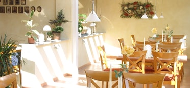 Mit Rosen dekorierter Frühstücksraum im Gästehaus Kraft in der Morgensonne