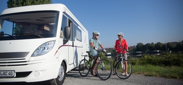 Zwei Radfahrer am Neckar vor einem Wohnmobil(THL)