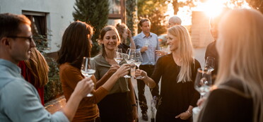 Landgut Steng: Weinprobe auf dem Hof - junge Leute im Sonnenuntergang mit Weingläsern (Foto: Landgut Steng)