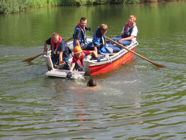 Fünf Personen in einem Motorboot der Feuerwehr auf dem Neckar
