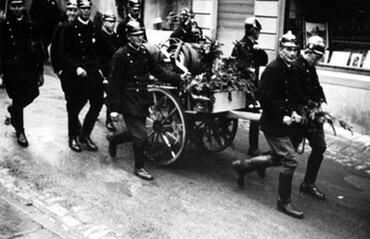 Historisches Schwarzweißfoto eines Hydrantenwagens mit Feuerwehrmännern