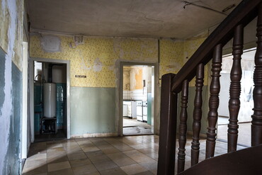 Blick vom Treppenhaus mit gedrechselten Sprossen auf Küche und Badezimmer