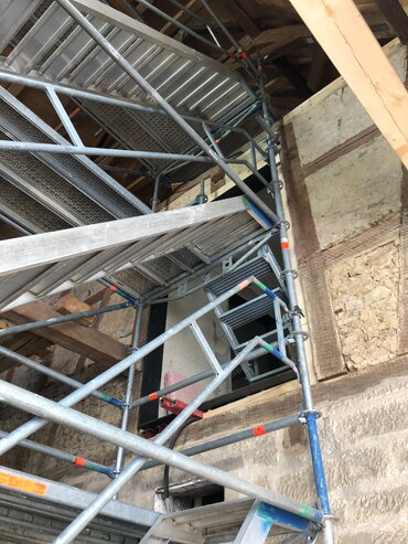 Blick von unten auf die provisorische Stahltreppe in der Altbauscheune