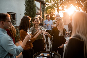 Landgut Steng: Weinprobe auf dem Hof - junge Leute im Sonnenuntergang mit Weingläsern (Foto: Landgut Steng)