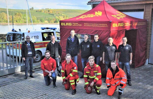 &Uuml;bergabe eines neuen Faltpavillions f&uuml;r die DLRG Gruppe Lauffen a.N. - auf dem Foto sind Mitglieder des DLRG in Uniformen zu sehen sowie der neue Pavillon und ein Vertreter der B&uuml;rgerstiftung