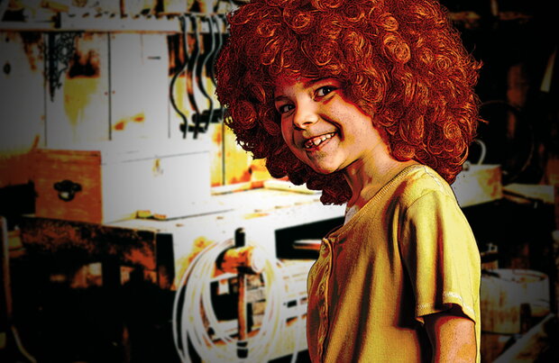 Pumuckl (Kind mit roter Wuschelperücke und gelbem Shirt) in der Werkstatt des Schreinermeisters Eder 