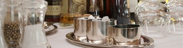 Silberne Zuckerschalen und Gläser auf weißer Tischdecke